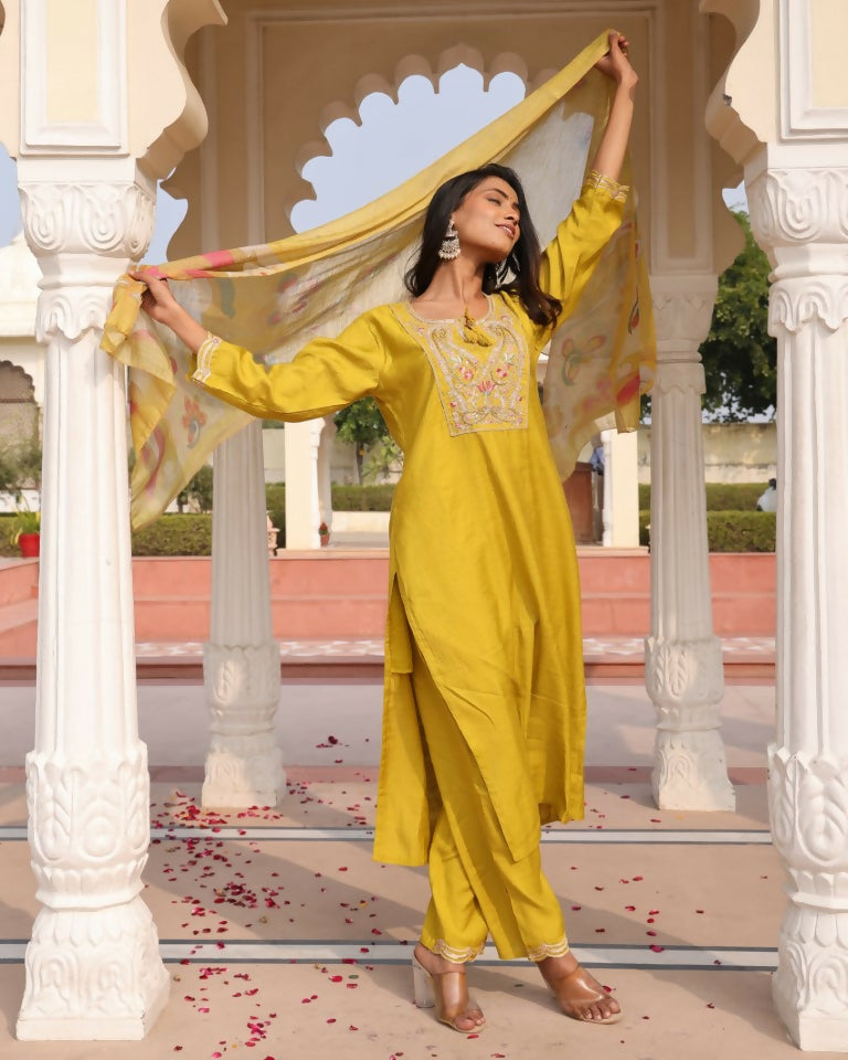 Woman wearing a yellow cotton silk straight kurta with floral prints and intricate handwork