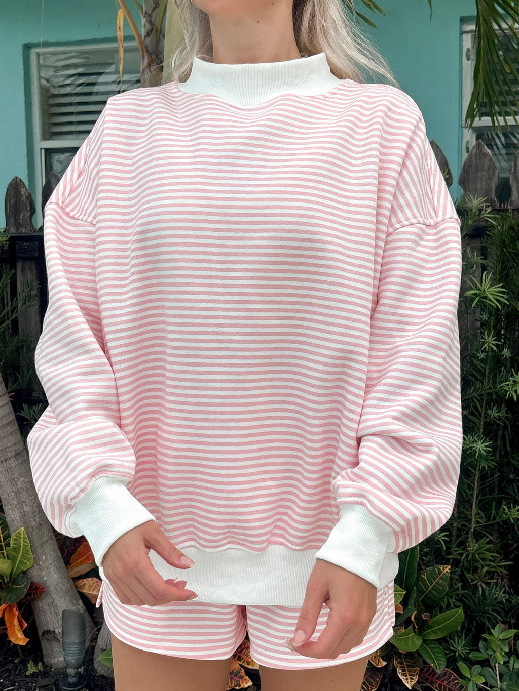 Light pink and white striped mockneck sweatshirt featuring a relaxed unisex fit.