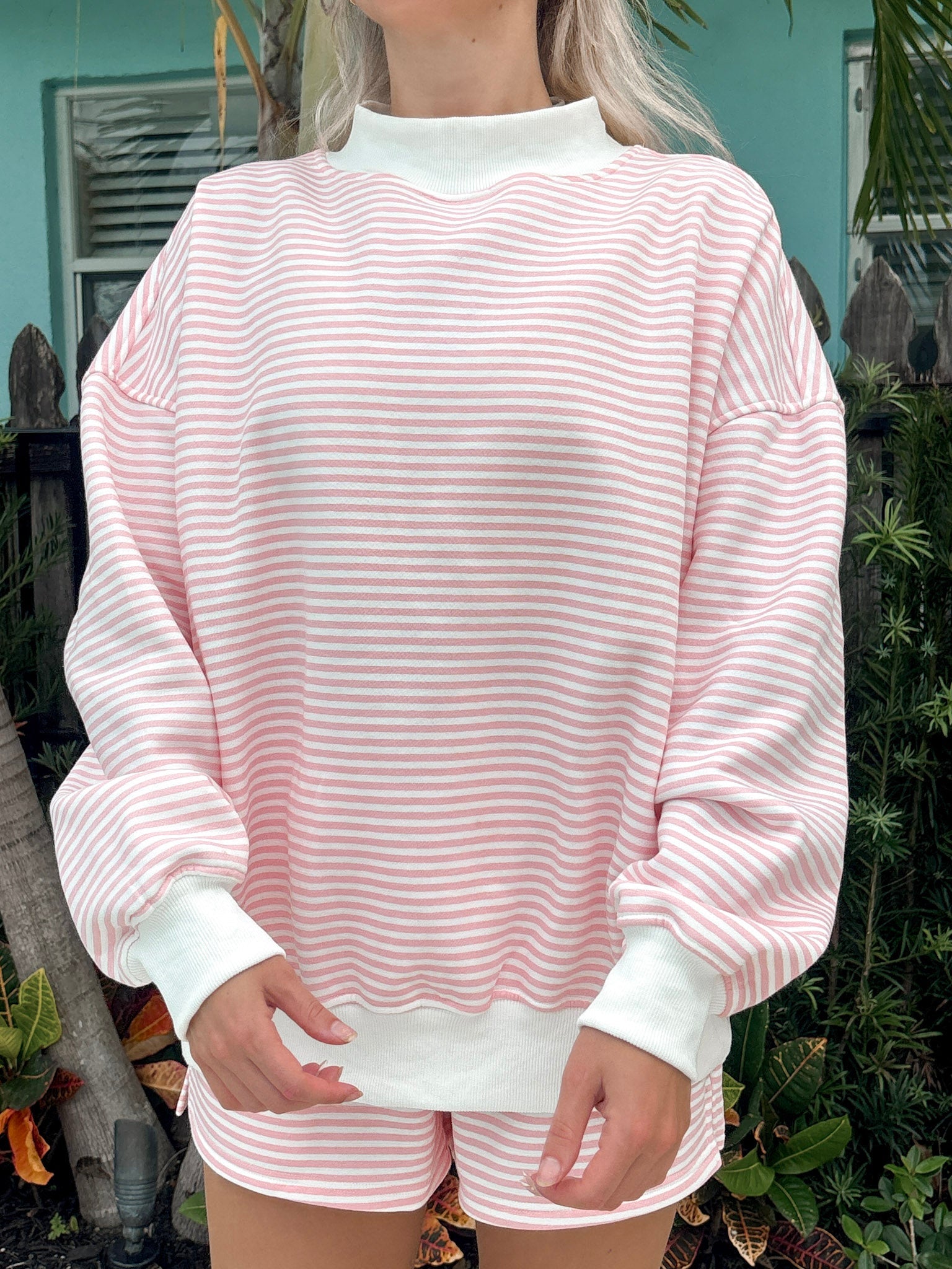 Light pink and white striped mockneck sweatshirt featuring a relaxed unisex fit.