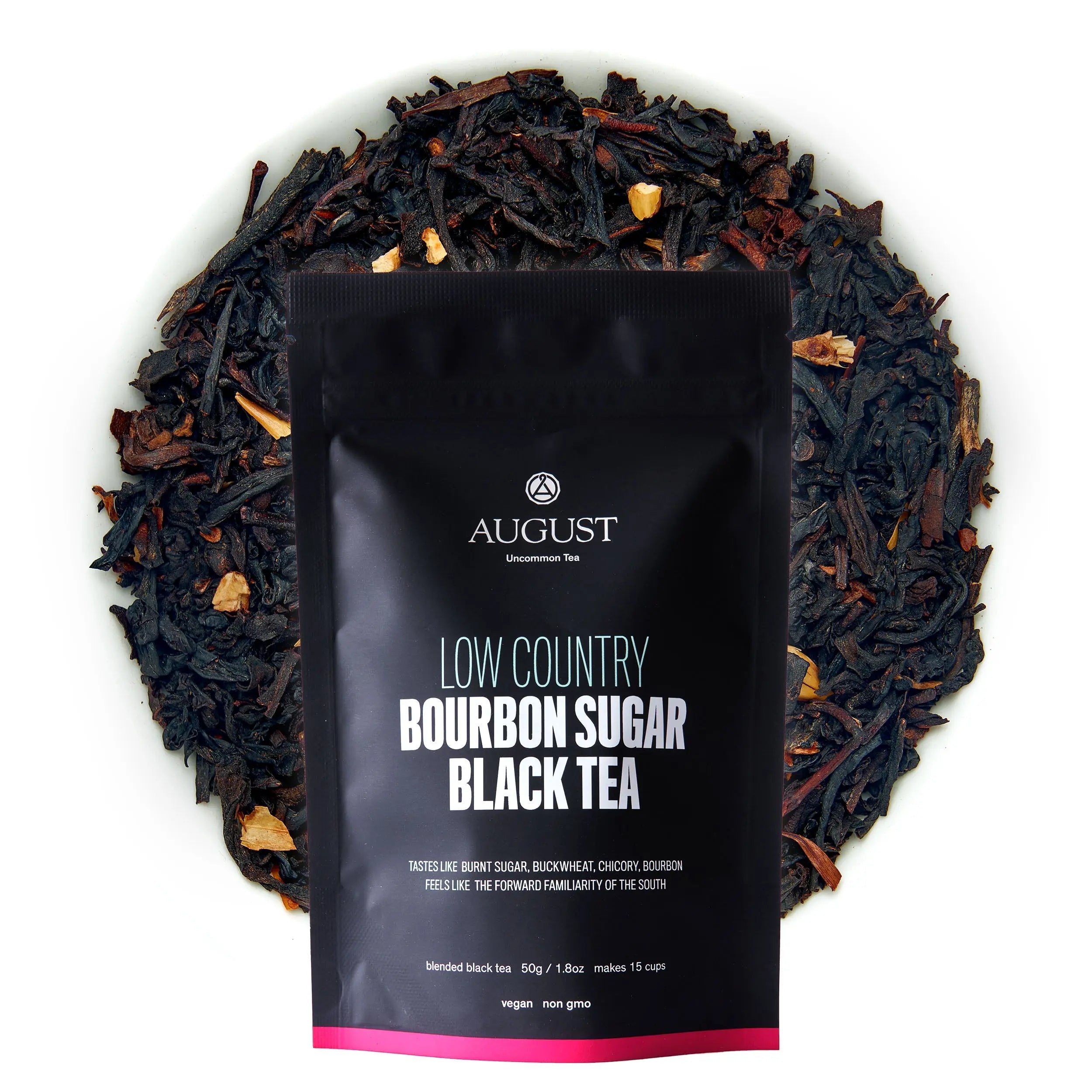 A black pouch of Low Country Bourbon Sugar Black Tea resting on a bed of dried loose tea leaves