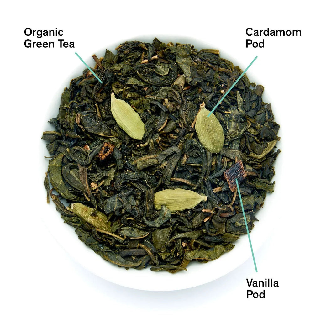 A close-up of Combray tea blend showing organic green tea leaves, cardamom pods, and vanilla pieces, next to a black tea pouch.