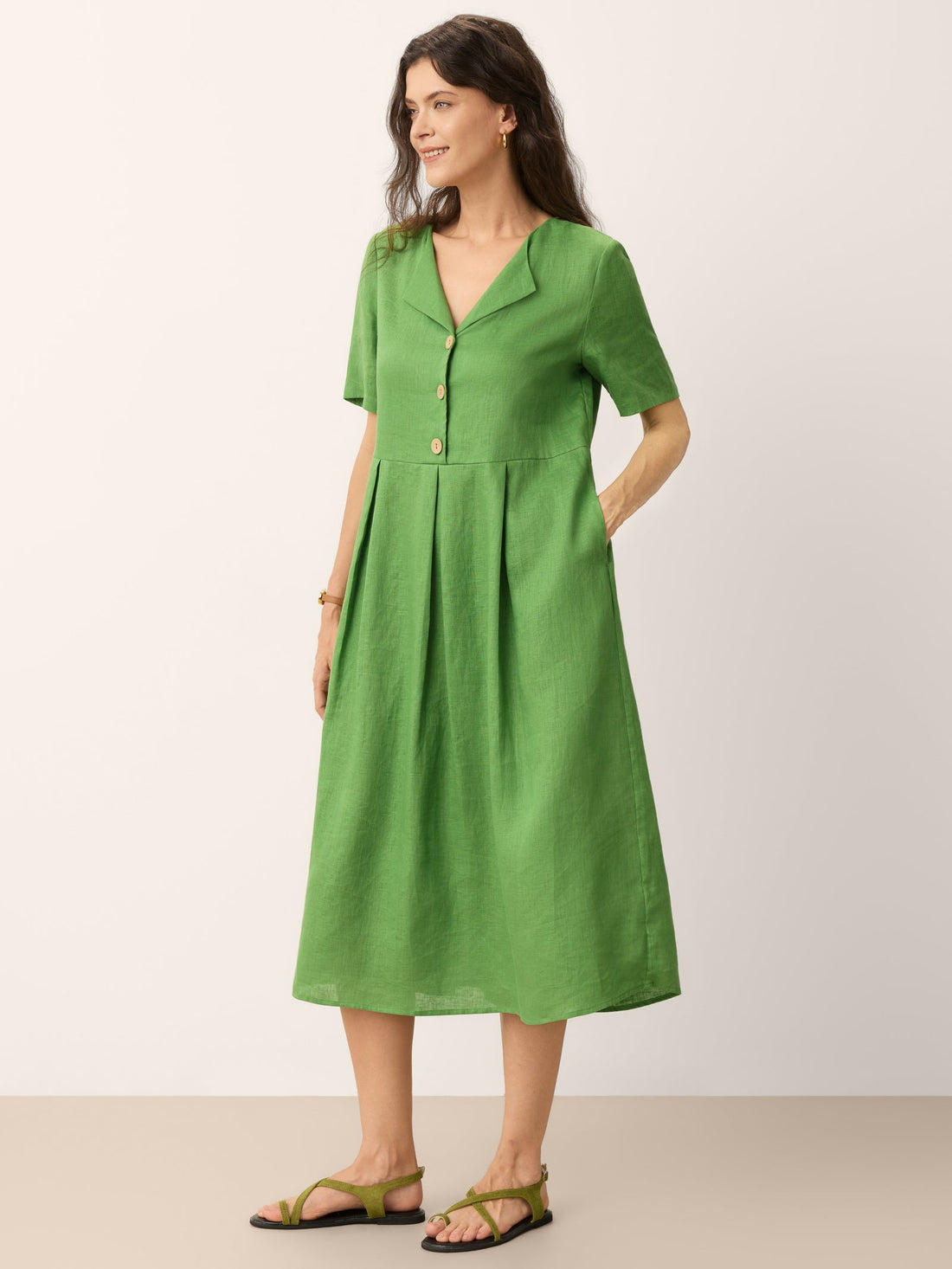 A 100% linen split neck midi dress in a relaxed straight silhouette with wooden button accents.