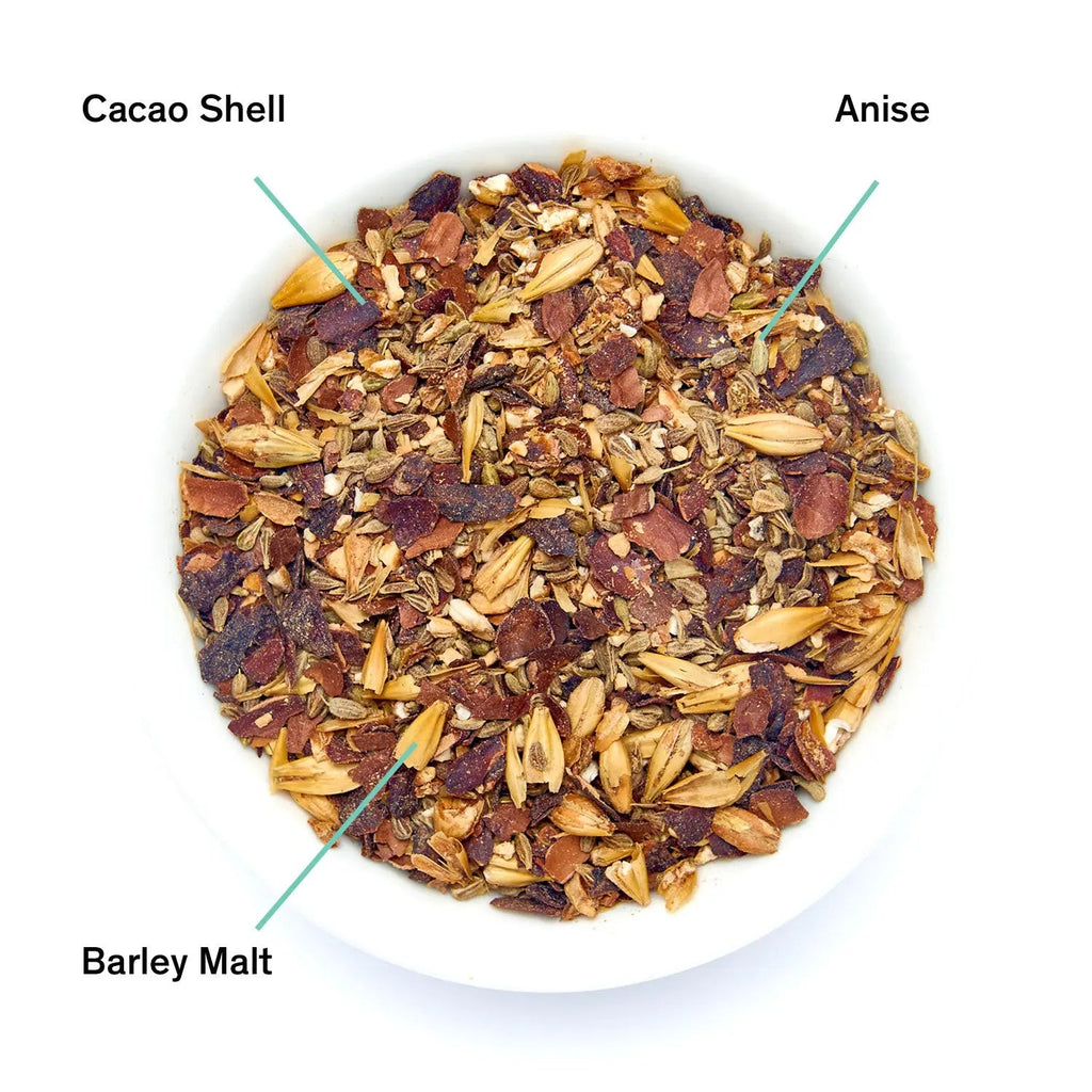 A pouch of Cult of Demeter herbal tea next to a bowl of loose leaf ingredients including barley malt, cacao shell, and anise.