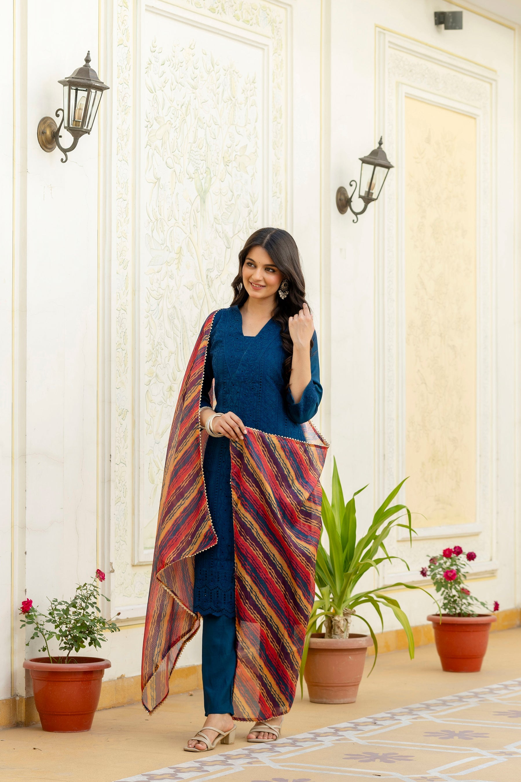 Woman wearing a Rama colored Roman Silk kurta set with intricate Chikan Kari embroidery and matching dupatta.