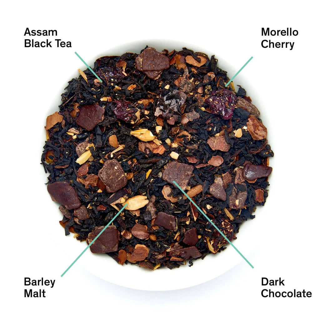 A pouch of Cabaret black tea next to a white bowl showing ingredients including Assam black tea, dark chocolate pieces, morello cherry, and barley malt.