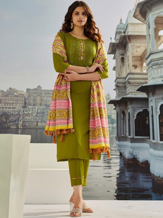 Woman wearing an olive-green muslin cotton salwar suit with pink and mustard geometric embroidery and dupatta.