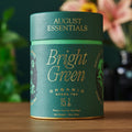 Cylinder container of Bright Green organic kukicha tea bags next to a bowl of loose kukicha tea leaves.