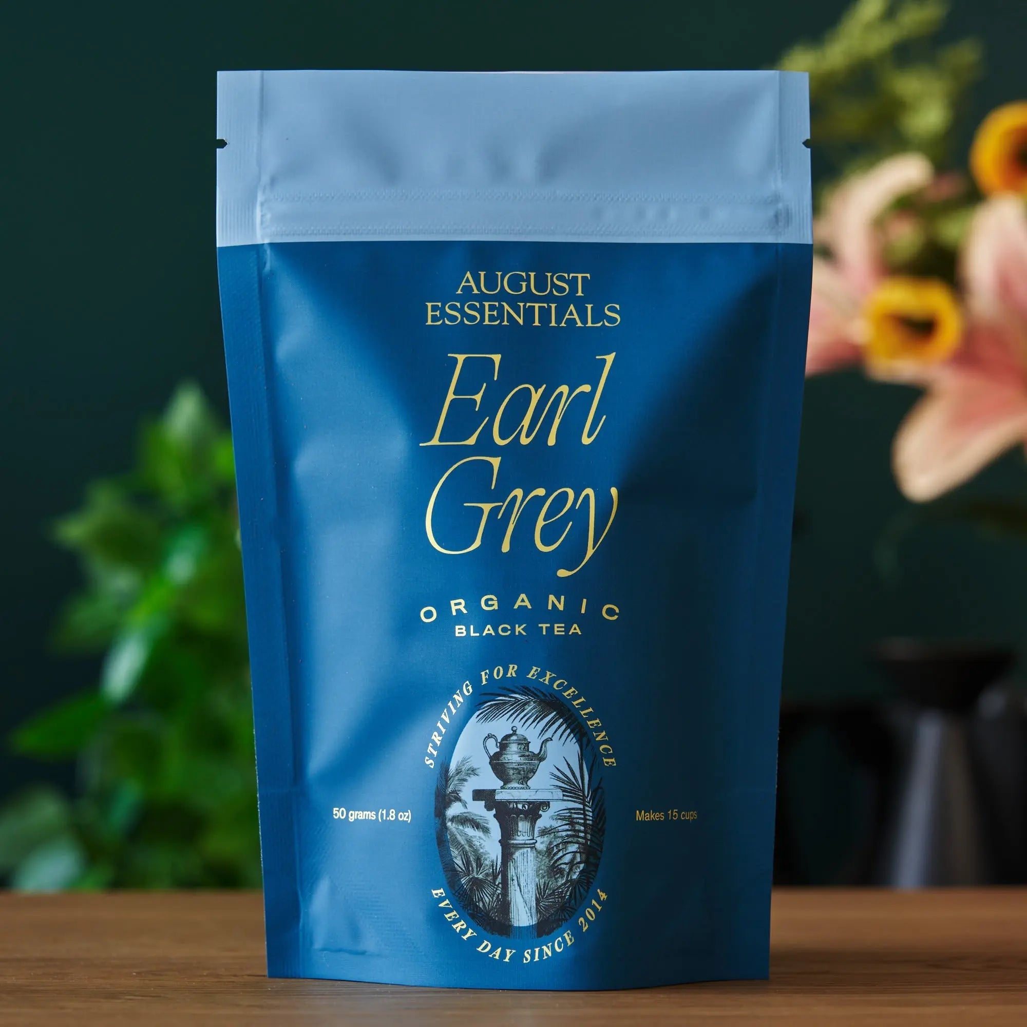 Organic Earl Grey black tea loose leaves in a bowl with cornflower petals, labeled 'Essentials Earl Grey'.