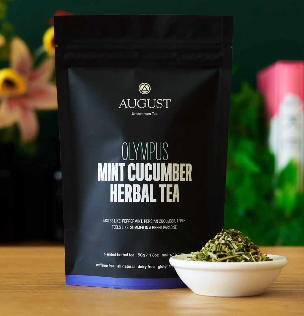 Bag of August Uncommon Tea Olympus blend next to a small bowl of dry loose leaf tea ingredients.
