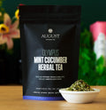 Bag of August Uncommon Tea Olympus blend next to a small bowl of dry loose leaf tea ingredients.