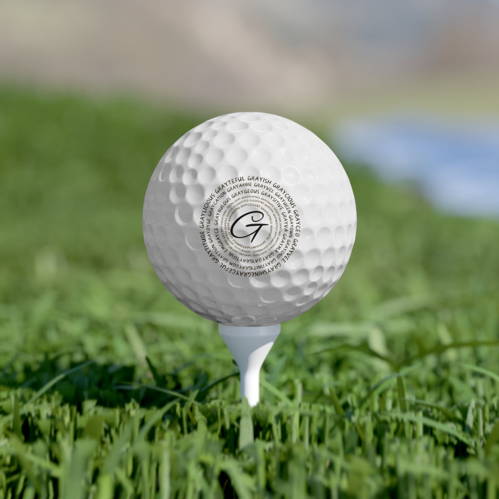 Close up of personalized bright white golf balls featuring custom branding on a golf green