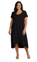 A woman wearing a rust-colored midi-length A-line knit dress with a scoop neck and an asymmetrical hem.