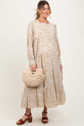 Pregnant woman wearing a yellow floral long sleeve tiered maternity maxi dress
