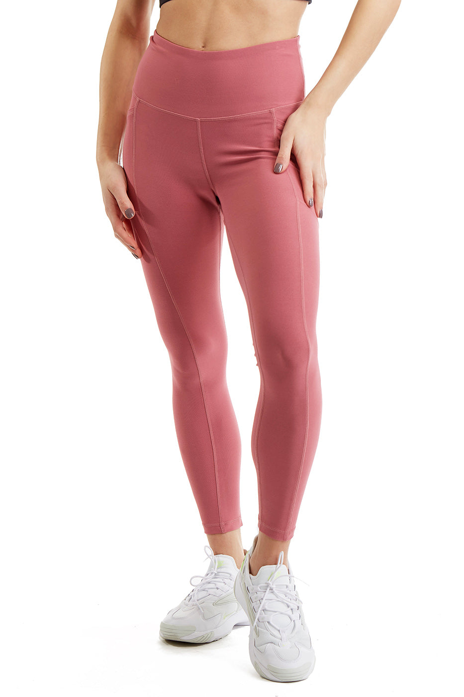 Woman wearing high-rise 7/8 athletic leggings with side phone pockets in solid color.