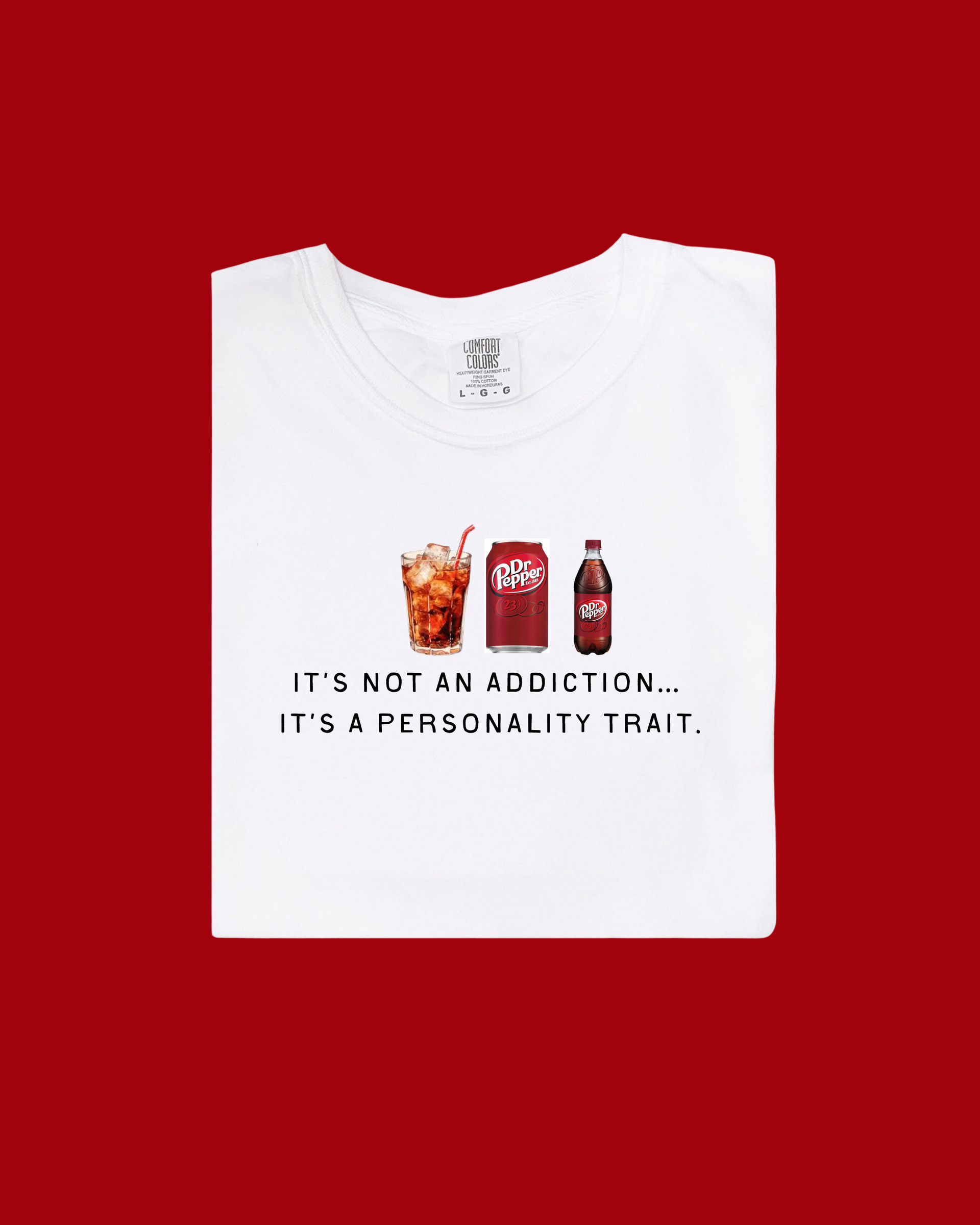 A Dr. Pepper branded graphic t-shirt featuring the slogan 'It's Not An Addiction, It's A Personality Trait' on a soft, casual tee.