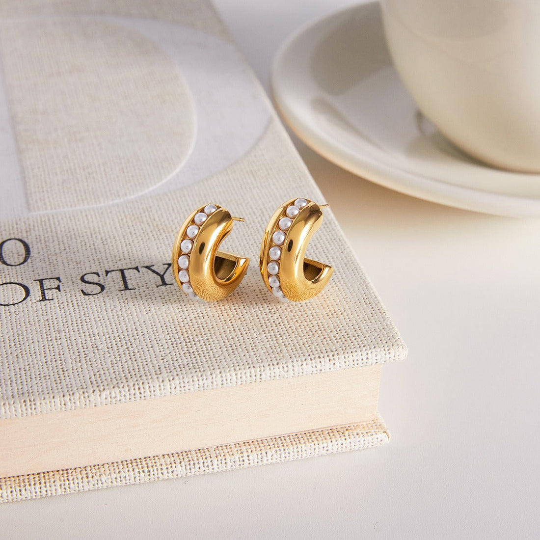 Minimalist 18K gold stud earring with a central embedded pearl.