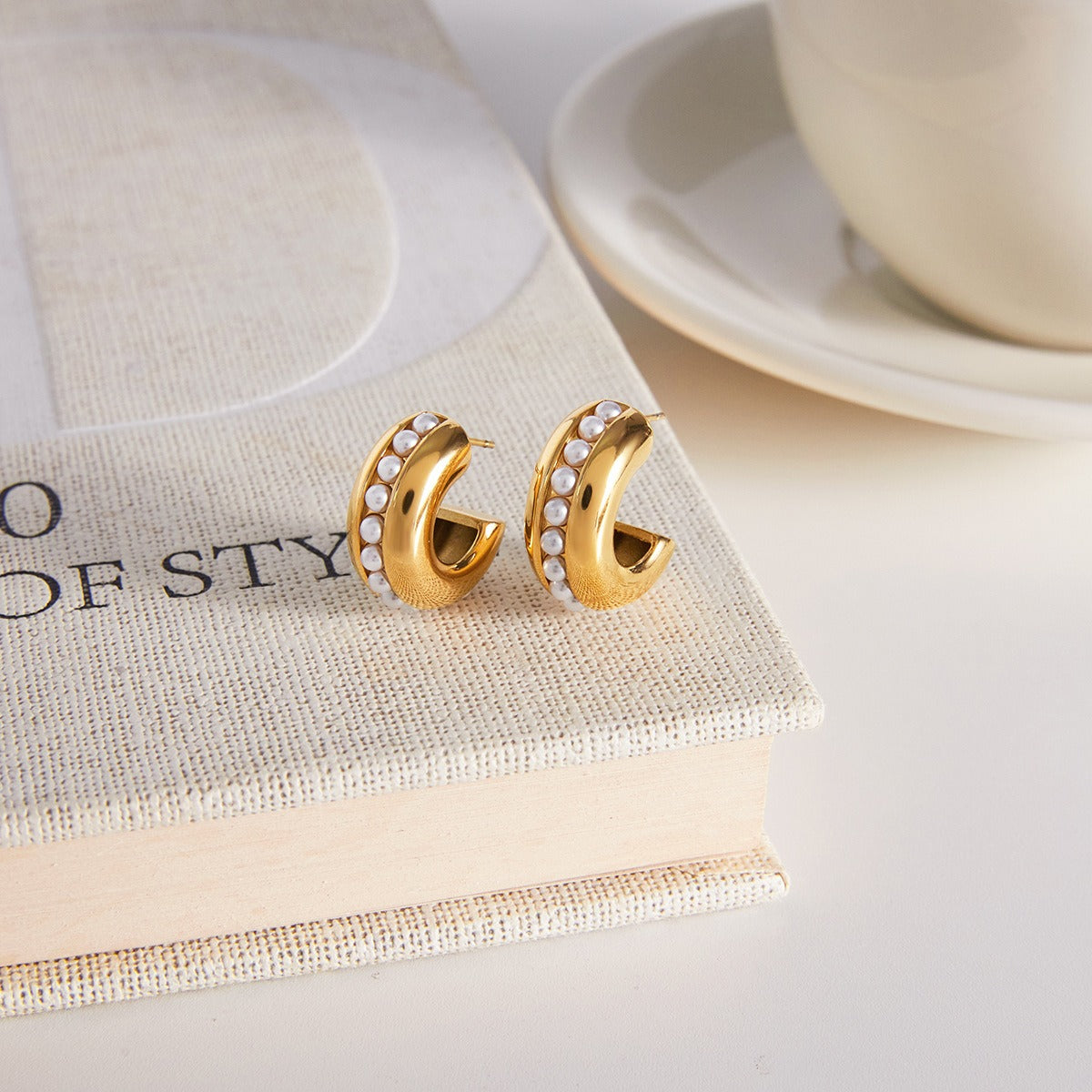Minimalist 18K gold stud earring with a central embedded pearl.