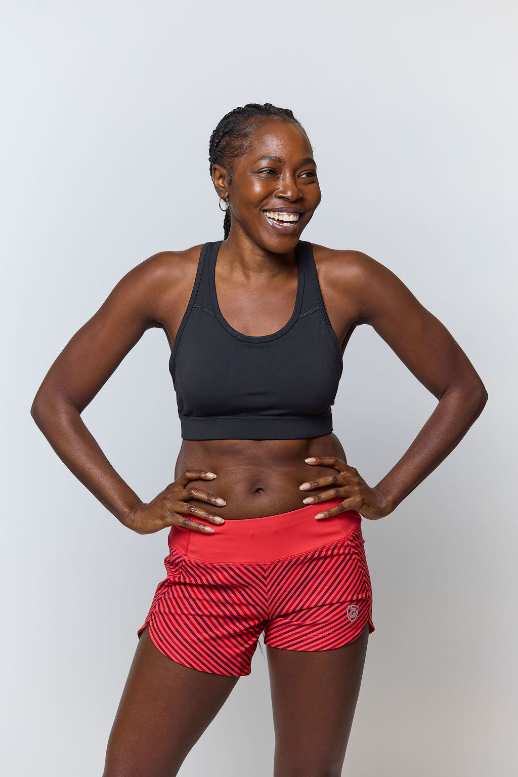 A black padded sports bra with a hexagonal crossover back design worn by a female athlete.
