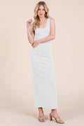 A woman wearing a fitted white ribbed sleeveless maxi dress with a scoop neckline.