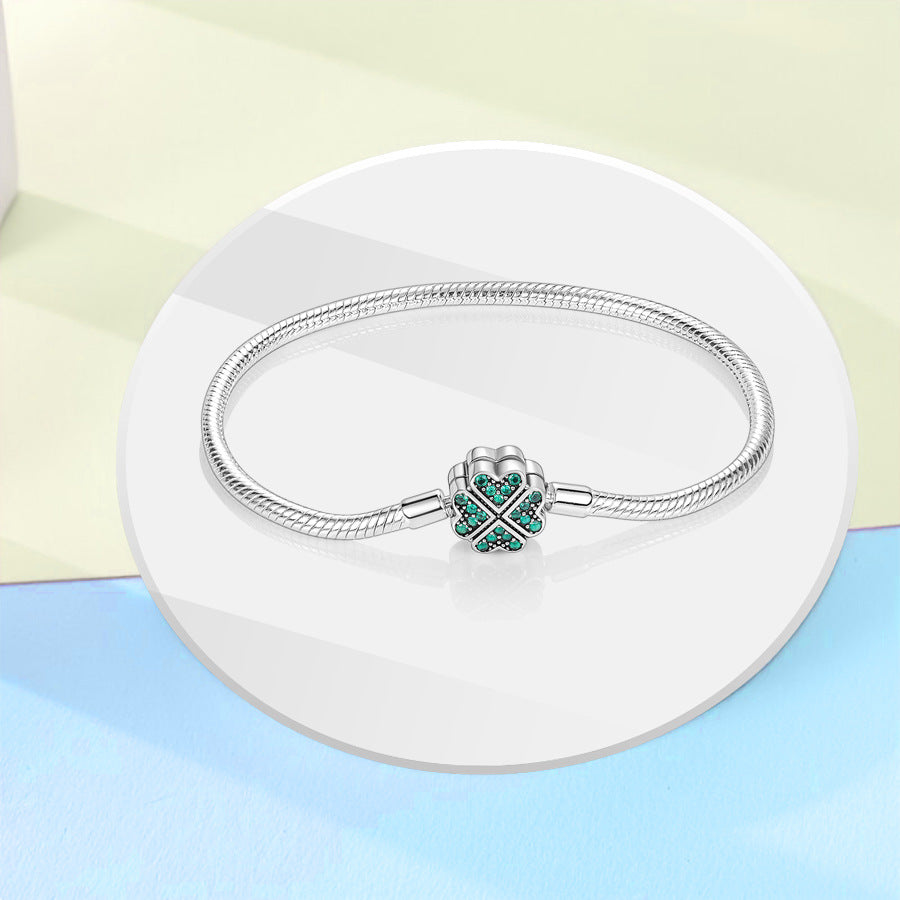 Vera Lux silver-plated woven heart bracelet with clover green zircon accent