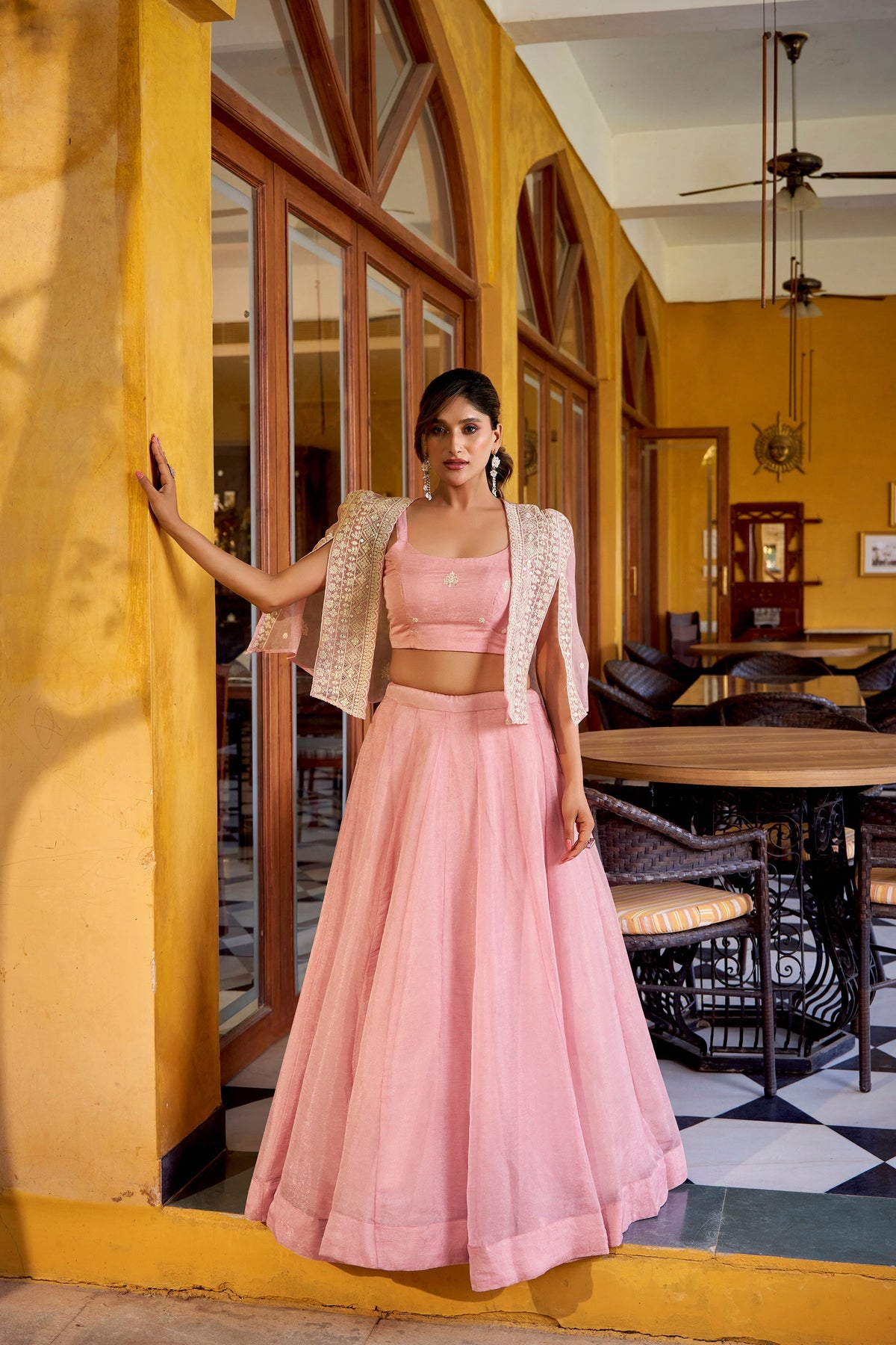 Model wearing a Lightpink Allnen Crush lehenga choli set with matching koti overlay