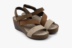 A pair of women's leather platform sandals in brown and beige tones featuring an adjustable velcro strap and orthopedic heel.