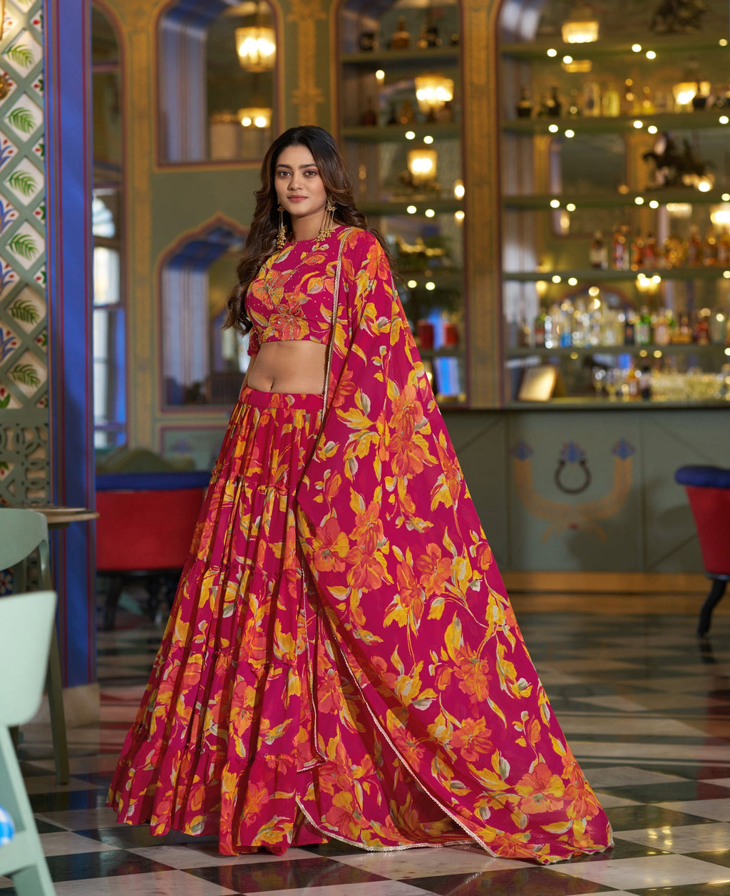 Model wearing a vibrant fuchsia pink and yellow floral print chiffon lehenga choli set with dupatta