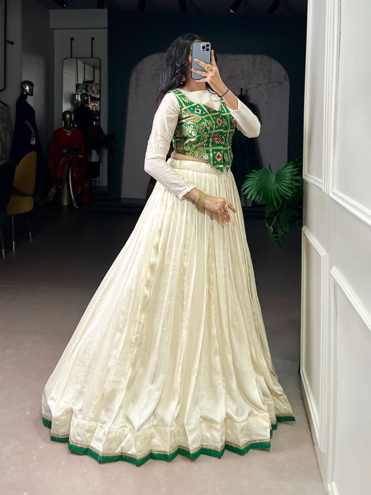 A woman wearing an off-white Vichitra silk lehenga choli with delicate lace detail