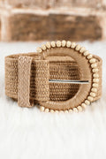 Close up of beige straw woven belt with delicate beaded details and pin-buckle closure, styled for a boho coastal look.