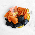 3-pack of Halloween-themed satin hair scrunchies in Pumpkin Orange, Yellow, and Industrial Black.