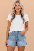 Women wearing high-rise medium-blue acid wash denim shorts with raw frayed hems and a zip-fly closure.