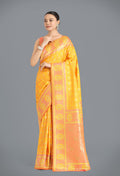 Vibrant yellow Banarasi silk saree with traditional zari woven patterns.