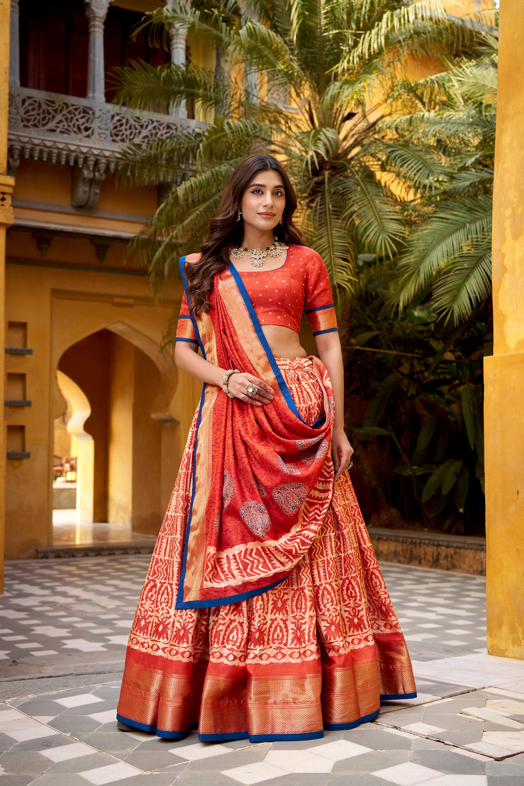 Rust colored Dola Silk lehenga choli with traditional Batik prints and Zari borders.