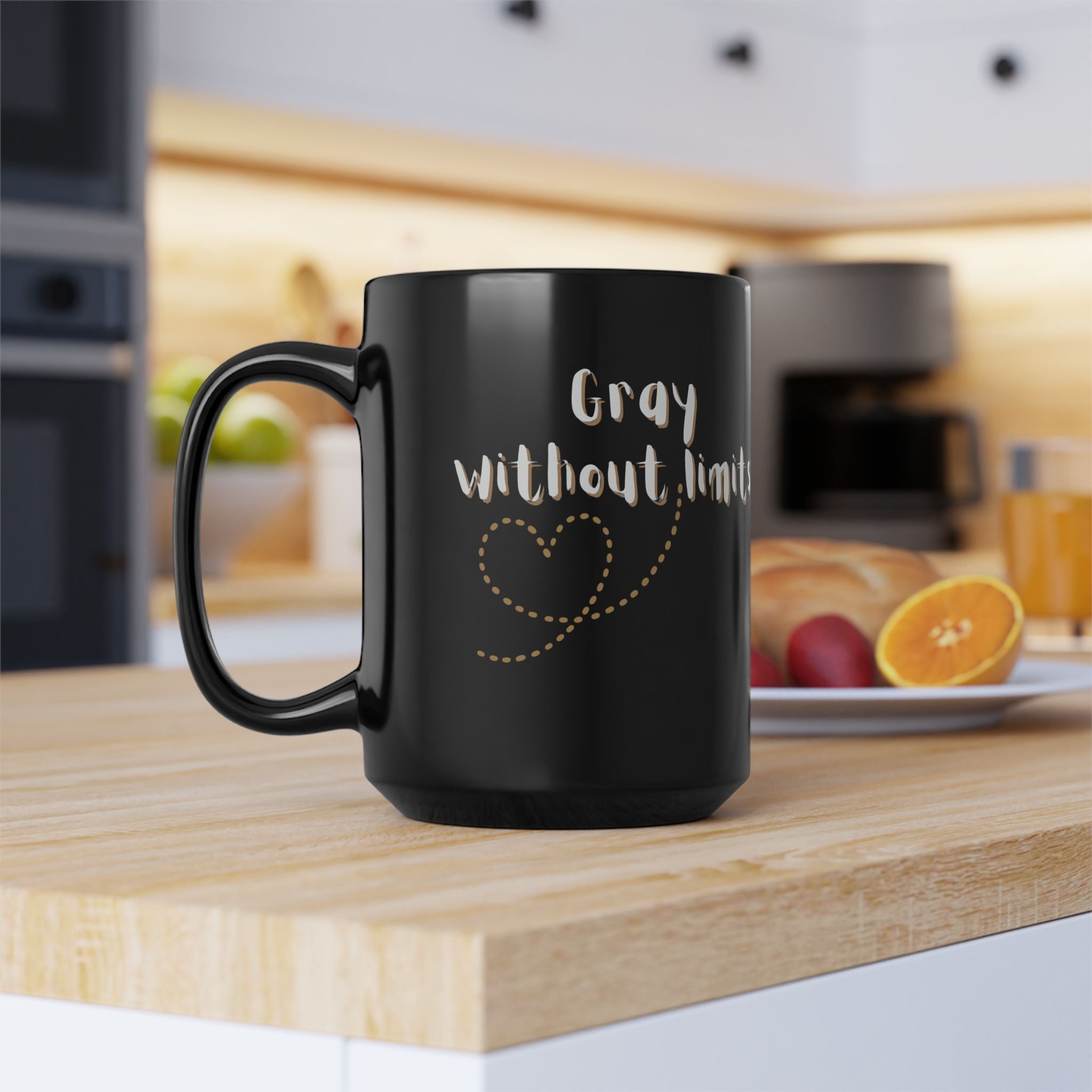 A sleek 15oz black glossy coffee mug with Gray Without Limits text in a modern kitchen setting.