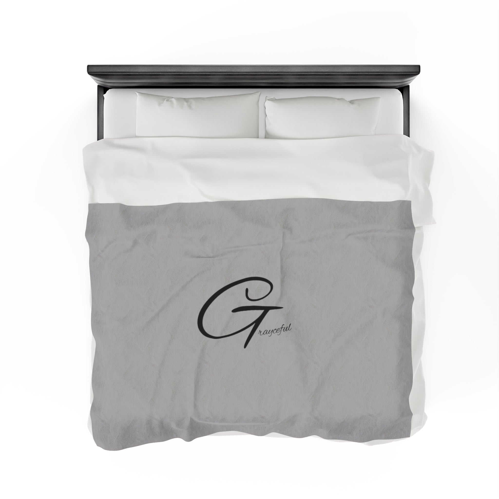 Minimalist cool gray velveteen plush throw blanket with black scripted logo draped on a modern sofa