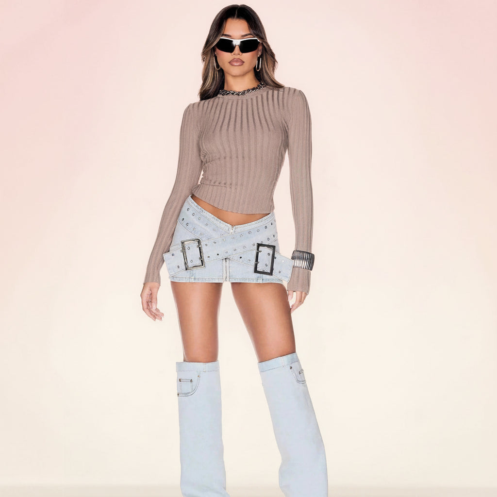 Front view of a light blue denim mini skirt featuring a stylish cross-over buckle design