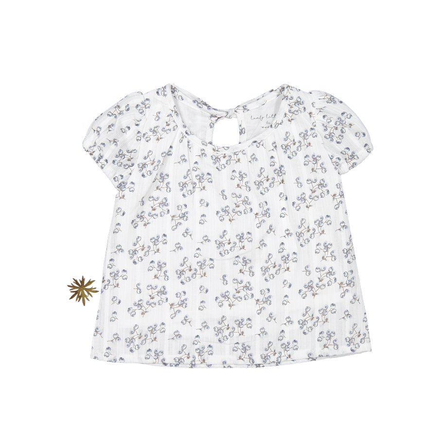 A white girls blouse with a blue berry and leaf floral print, featuring puff sleeves and a tie-neck detail on a clean background.