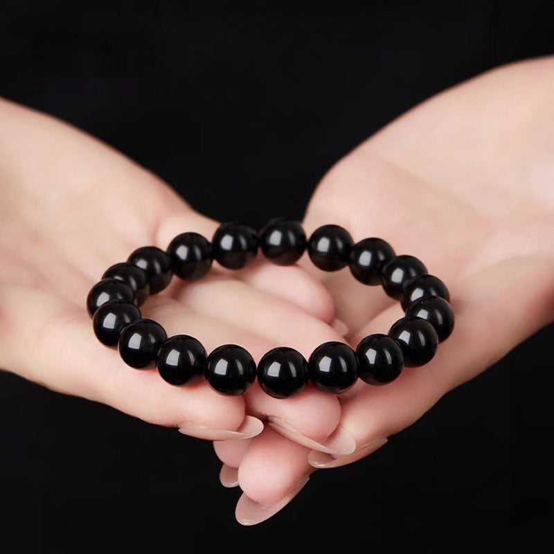 Polished black obsidian beaded bracelet in a geometric loop style