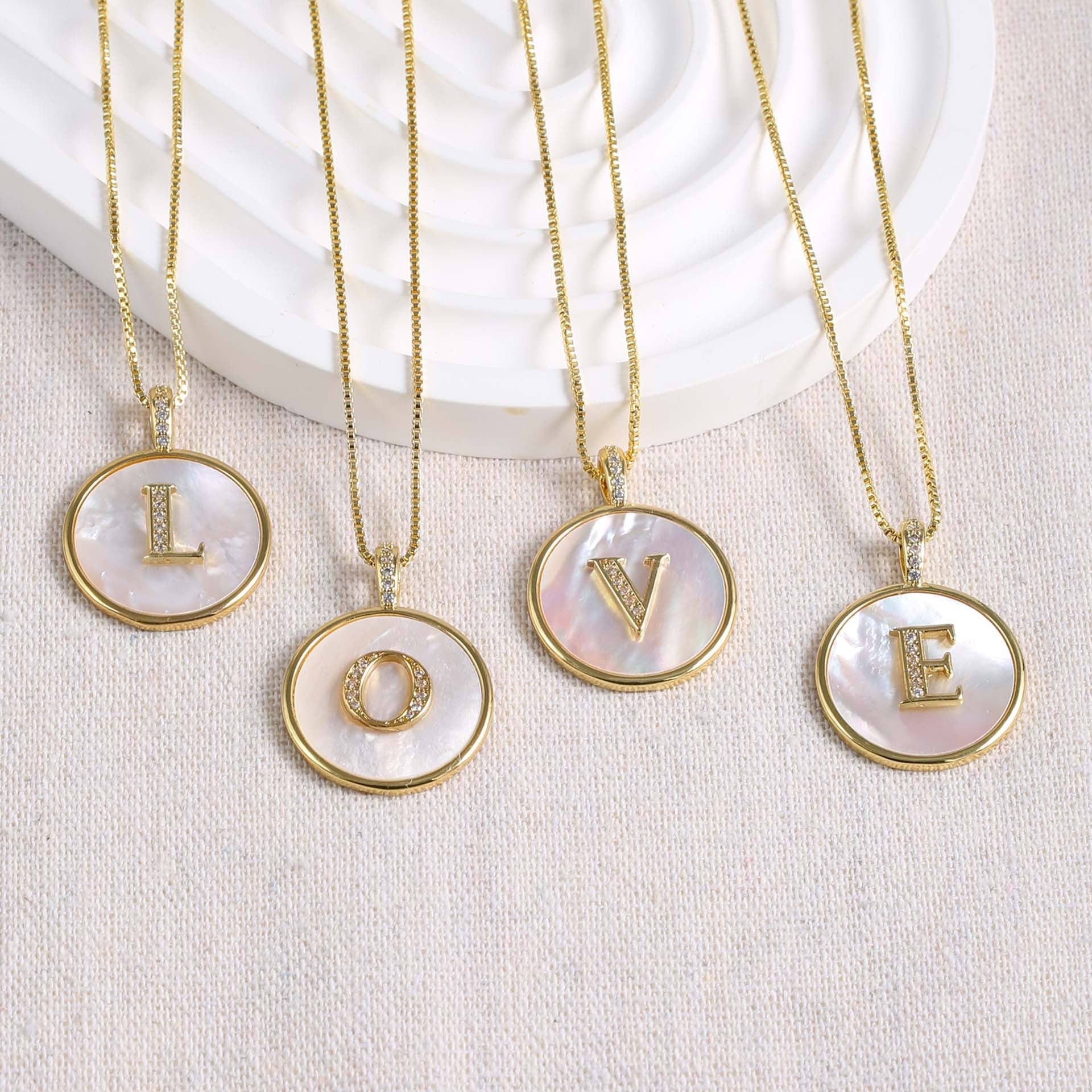 Close up of a Gold Shell Initial Pendant Charm on a delicate chain