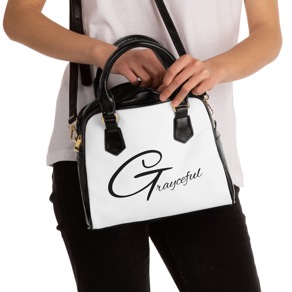 Minimalist black leather shoulder handbag with zip closure and clean aesthetic