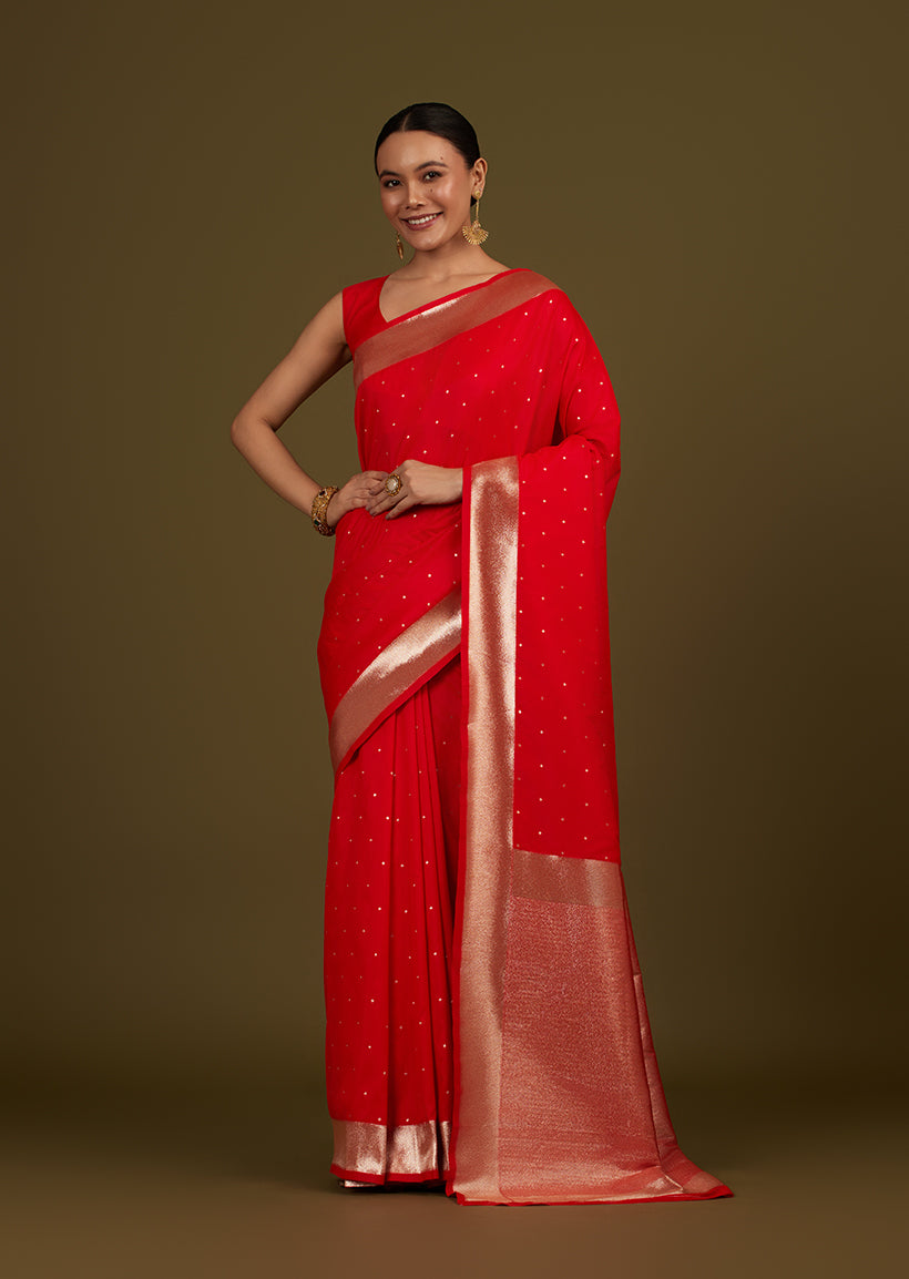 Red woven silk blend saree decorated with gold zari work and floral motifs