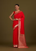 Red woven silk blend saree decorated with gold zari work and floral motifs