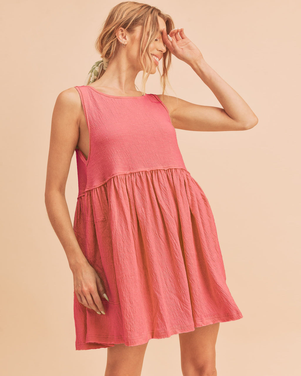 Woman wearing a pink round neck mini tank dress in a casual bohemian style