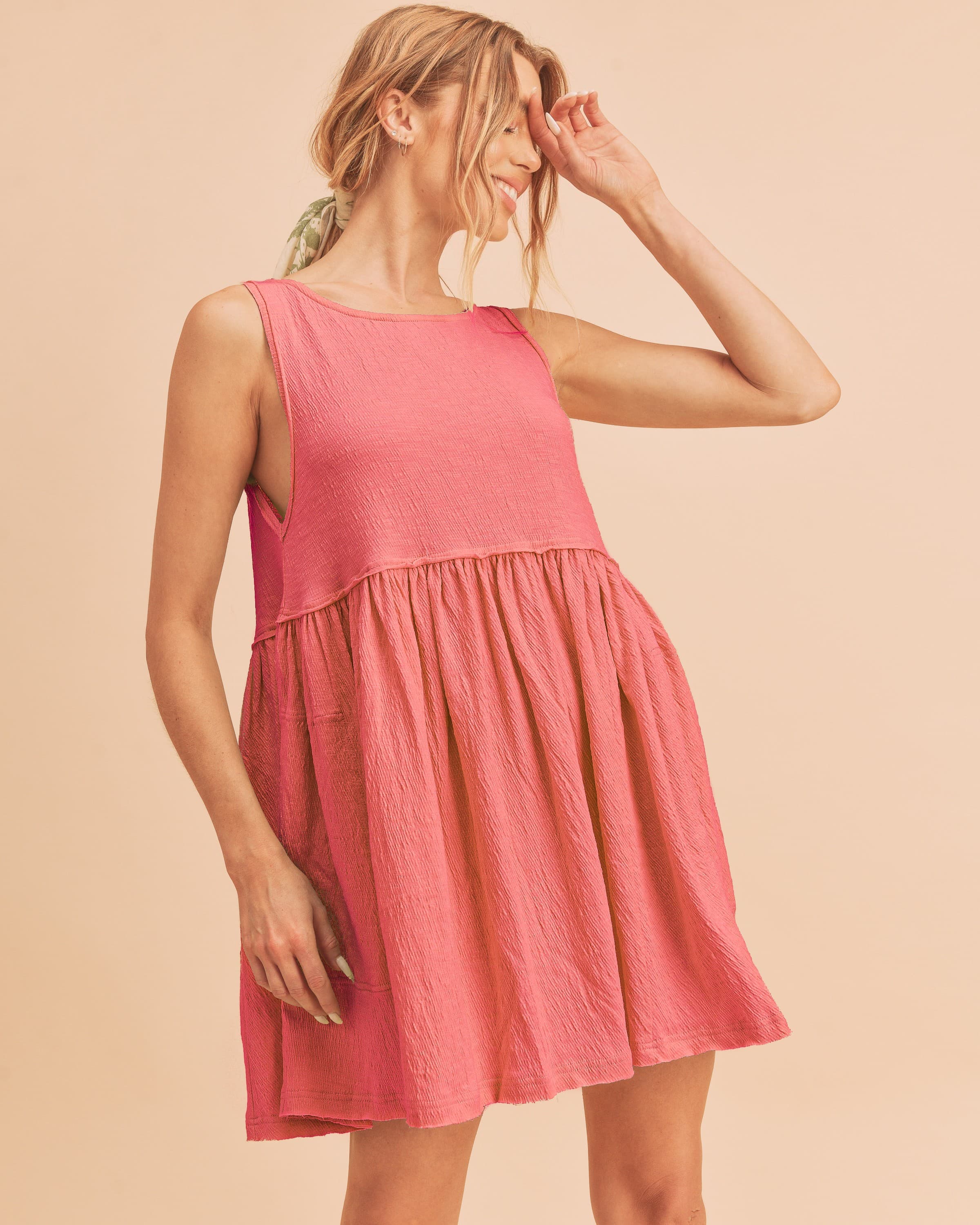 Woman wearing a pink round neck mini tank dress in a casual bohemian style
