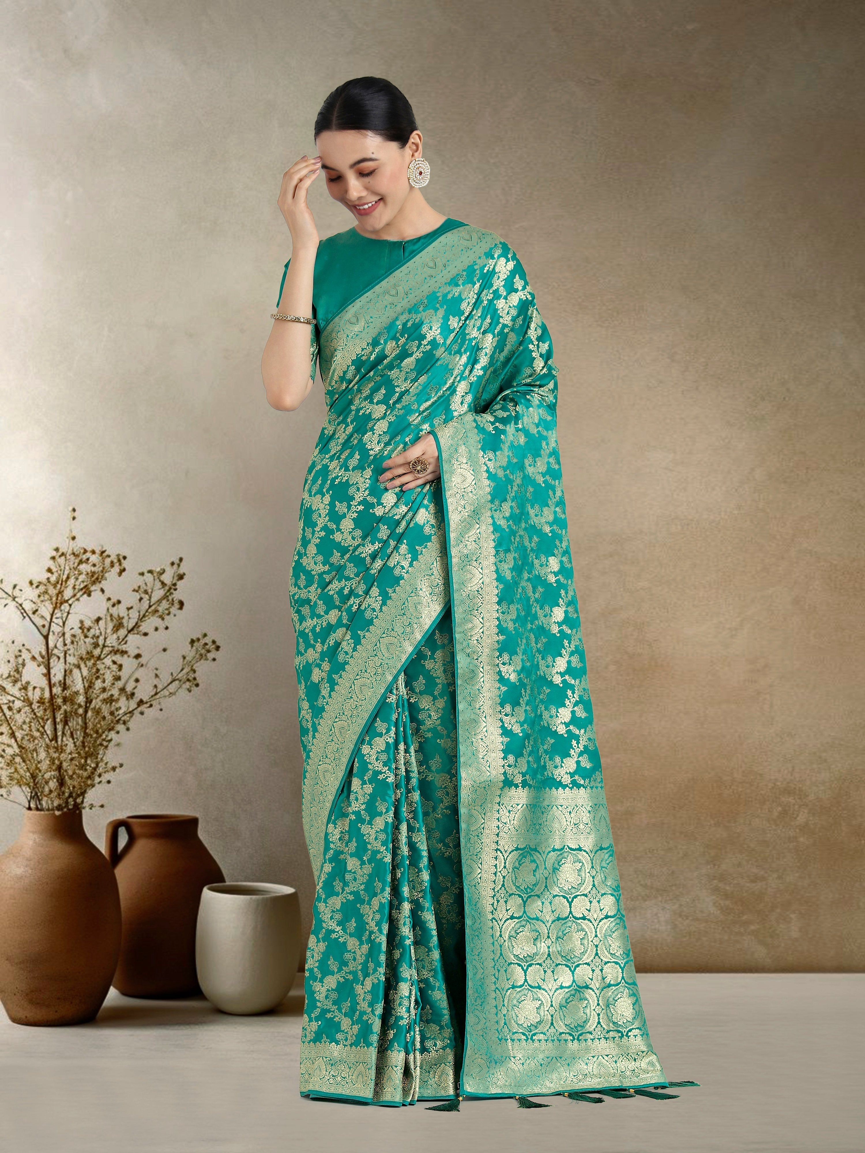 Effervescent turquoise Banarasi satin silk saree featuring delicate Zari weaving and matching blouse fabric.