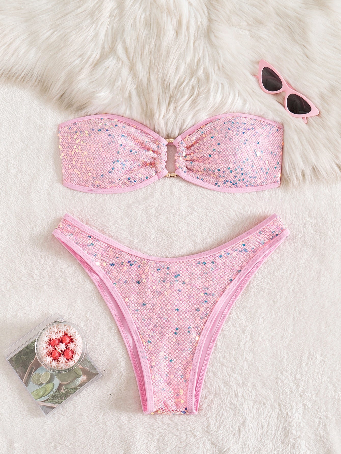 Close up of a glamorous strapless sequin bikini with gold ring and cutout details.