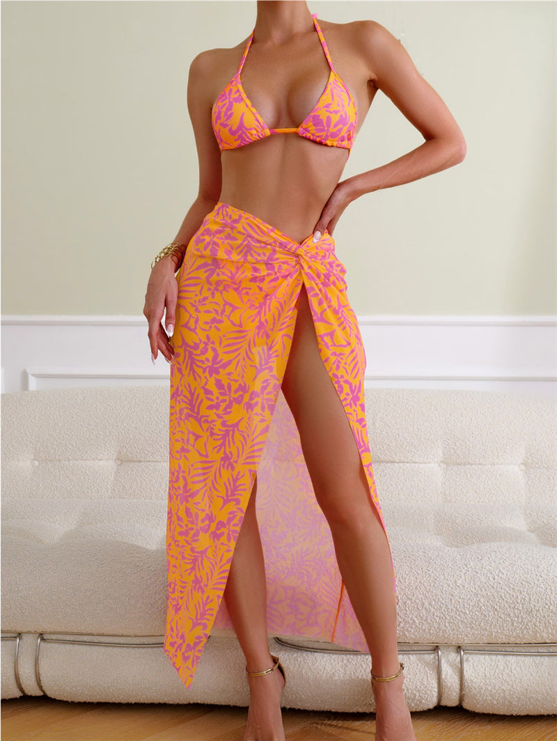 A stylish three-piece floral printed beach swimsuit with an open back and tie-up halter neck design.