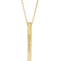 Amélie 14K yellow gold four-sided engravable bar necklace resting on a neutral background