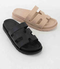 A pair of minimalist Gino Black sandals showing the cushioned footbed and sleek silhouette.