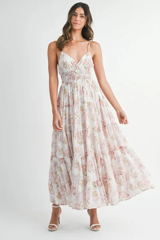 A flowy floral print tiered maxi dress with cami straps in white and pink.